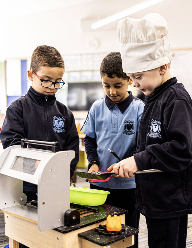 Children playing in a toy kitchen at St Madeleine's Catholic Primary School Kenthurst
